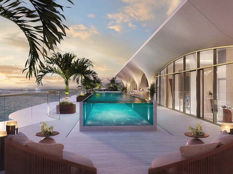 At the heart of Ocean House by Ellington Properties lies a commitment to exquisite oceanside living. Within this haven, a diverse range of 2 to 6-bedroom apartments, duplexes and penthouses awaits. As you step into the lobby, you'll be greeted by a minimalist hotel-like ambiance, defined by a double-height ceiling and elegant neutral decor. Lush greenery enhances the welcoming atmosphere, creating a serene sanctuary for residents and guests alike. Inside, these thoughtfully crafted abodes open to a world of contemporary elegance. With spacious designs and sophisticated neutral palettes, the interiors of Ocean House exude tranquility and sophistication. Floor-to-ceiling windows flood the space with natural light, offering residents breathtaking views of the surroundings. As you explore further, you'll find yourself drawn to the lush private pools and gardens, offering a tranquil retreat amidst the bustling city. Designed with utmost privacy and serenity in mind, these outdoor spaces provide residents with a sanctuary to relax and unwind. Venturing beyond the confines of your home, you'll encounter a wealth of private club-inspired amenities, including a 50-meter Olympic swimming pool, a wellness studio, clubhouse and cinema room.  Starting at AED 9.5M, Ocean House by Ellington Properties offers 2 to 6-bedroom apartments, duplexes and penthouses. The handover is expected in Q2 2026 with a 70/30 payment plan.