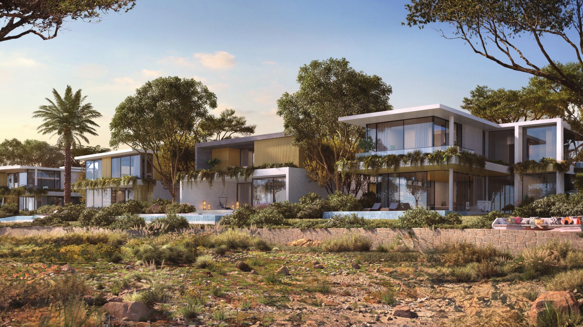 Maha Villas by Expo Dubai offers a distinctive living experience within Expo City. This new collection of 5-bedroom villas presents a serene retreat from the city's pace, nestled amidst lush green spaces and designed with a modern touch. The exterior of Maha Villas is marked by clean lines and expansive facades that merge seamlessly with the surrounding environment. The villas feature large glass windows and private terraces, allowing natural light to flood the interiors and offering panoramic views of the tranquil community. The architectural design emphasizes open spaces and a harmonious connection between indoor and outdoor living. Inside, the villas are crafted to accommodate a range of lifestyles with flexible layouts and premium finishes. The ground floor includes versatile spaces that can serve as home offices or fitness areas. The living areas flow into private gardens, creating a seamless transition between indoor comfort and outdoor leisure. Each villa is outfitted with modern kitchens, spacious living rooms and multiple en-suite bedrooms. Amenities include landscaped courtyards, semi-private gardens and easy access to urban farming. A blend of form and function defines the Maha Villas where the design emphasizes both beauty and practicality.